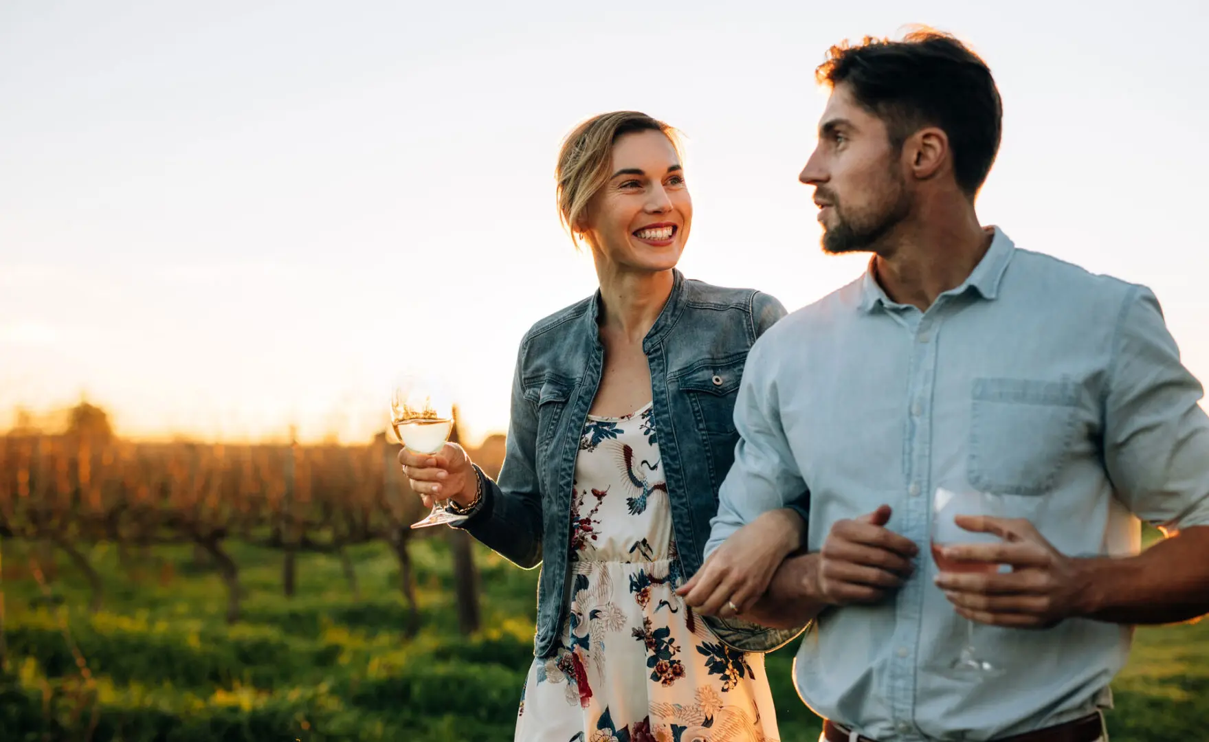 A man and woman holding wine glasses in their hands.